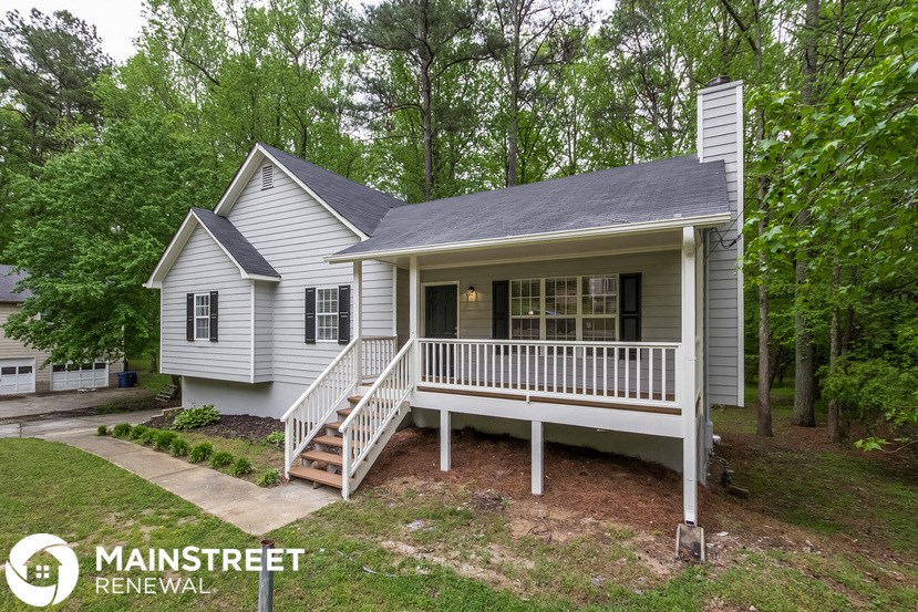 a small white house with a porch and a white
