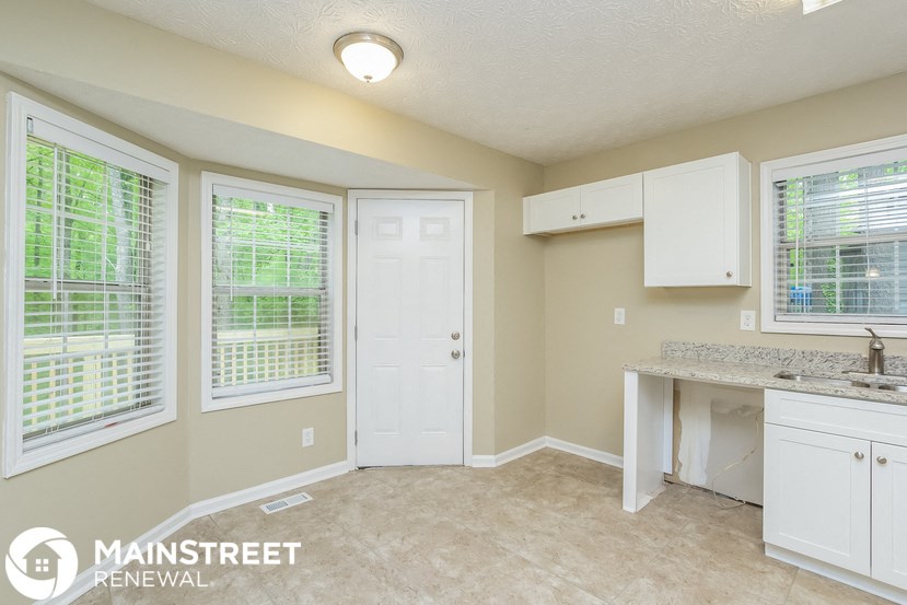 a kitchen with white cabinets and a counter top and a sink