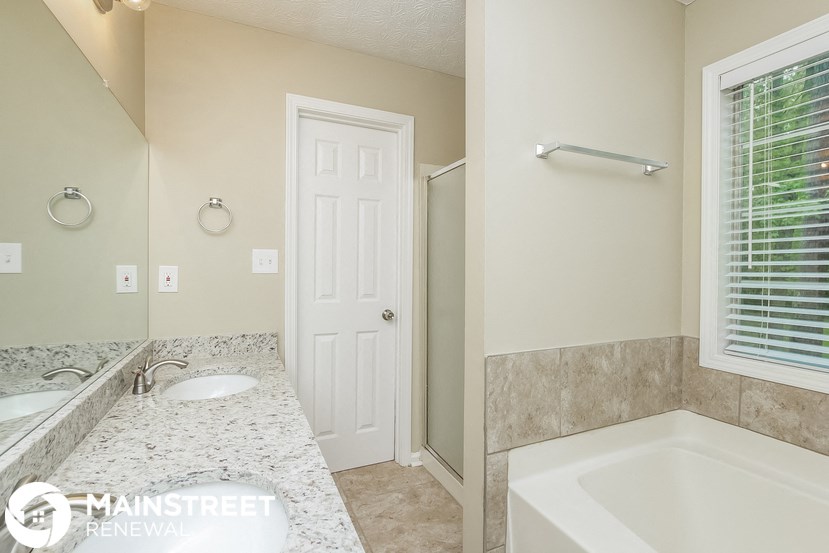 a bathroom with a tub and a sink and a mirror
