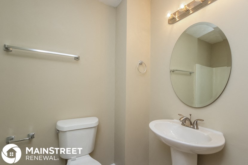 a bathroom with a sink toilet and a mirror