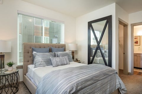 a bedroom with a large bed and a mirror