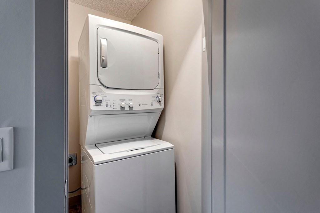 A white washing machine and dryer in a small laundry room.