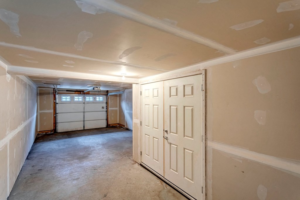 A room with a white door and a window with blinds.
