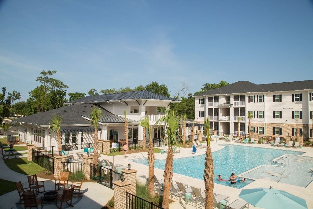a large swimming pool in front of an apartment building