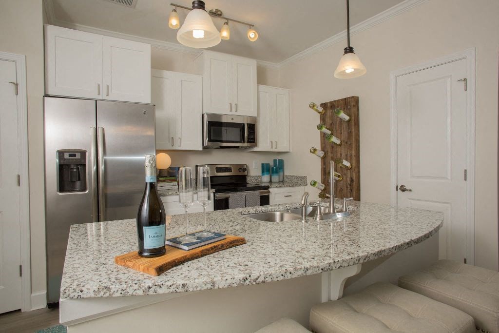 a kitchen with a counter top with a bottle of wine