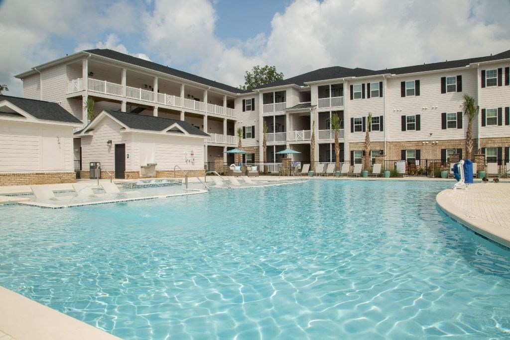 a large swimming pool in front of an apartment building