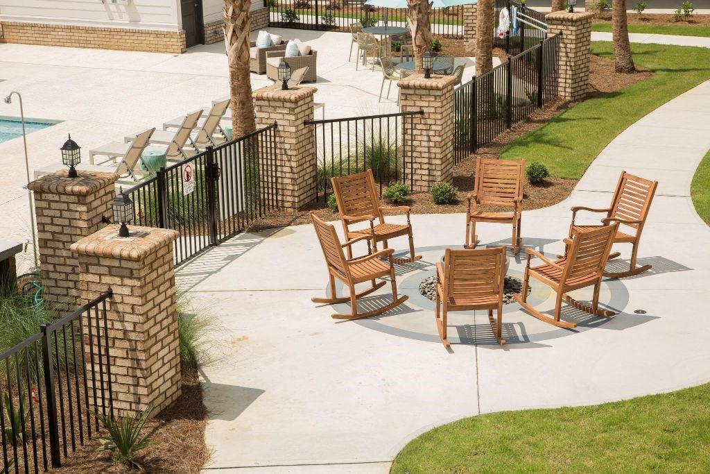 a group of wooden chairs sitting on a patio next to a pool