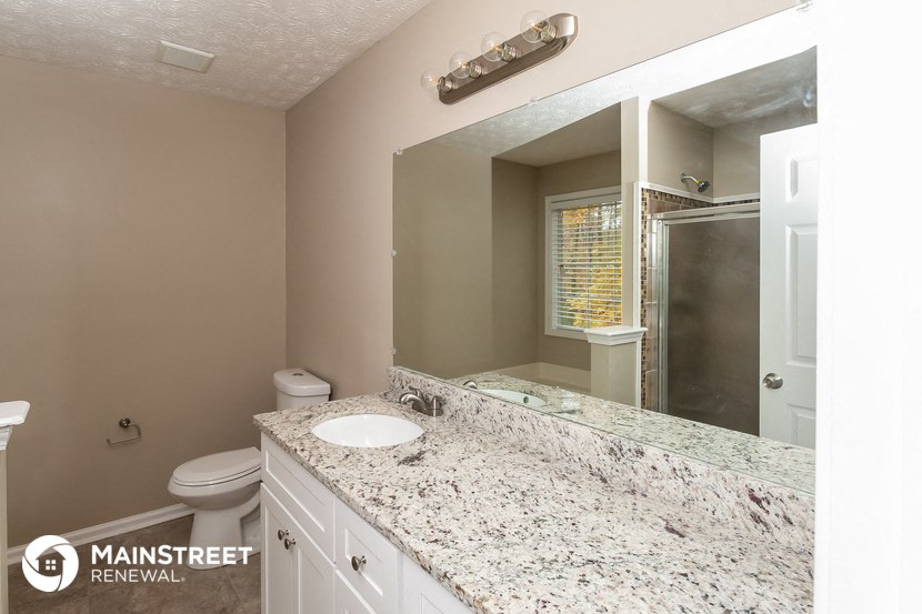 a bathroom with a sink and a toilet and a mirror