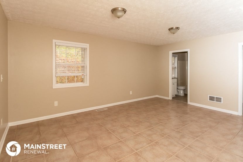 the spacious living room with tile flooring and beige walls