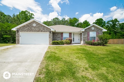 a brick house with a white garage door and a lawn