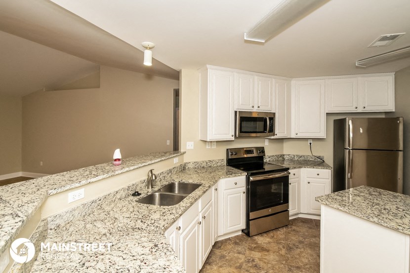 a kitchen with granite counter tops and white cabinets