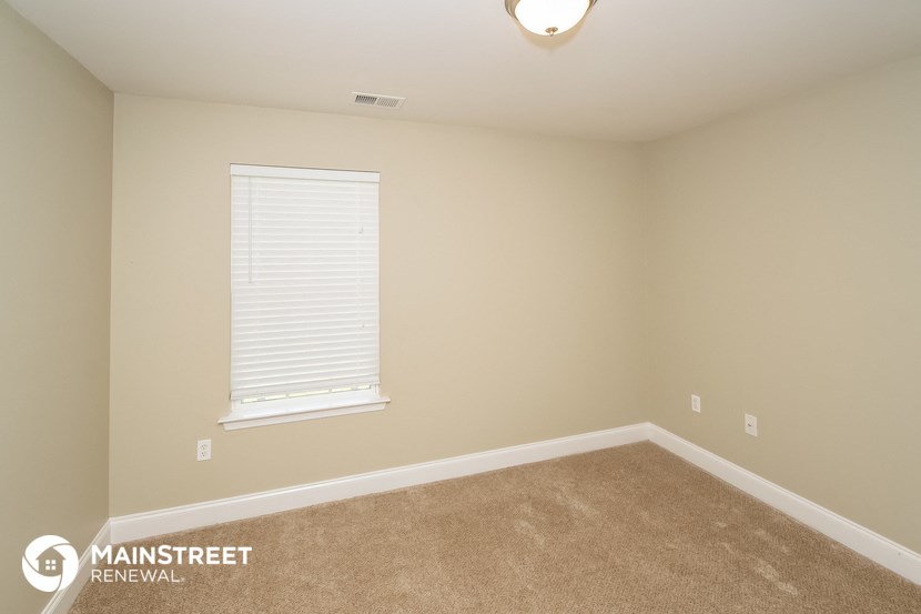 a bedroom with a carpeted floor and a window