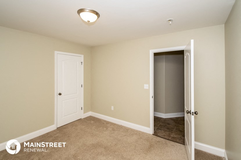a bedroom with a closet and a door to a bathroom
