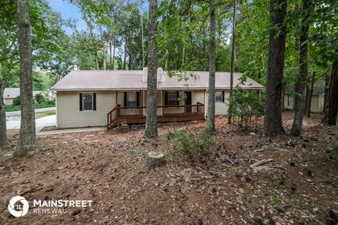 a small white house in the middle of the woods