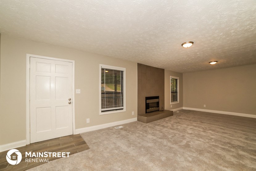 a living room with a white door and a fireplace