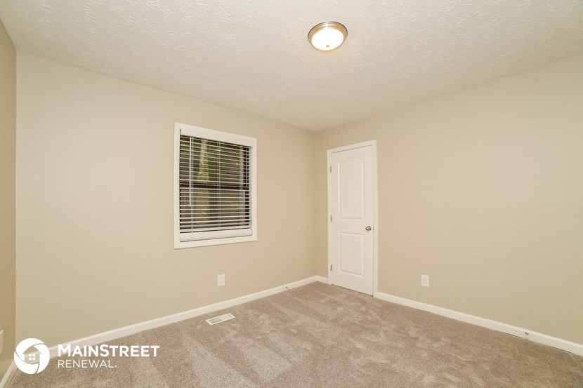 the upstairs bedroom has a carpeted floor and a white door