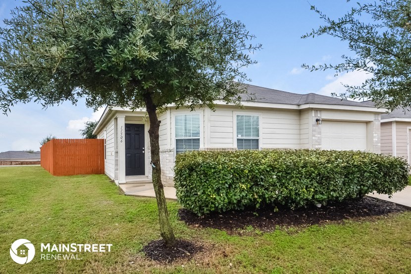 a small white house with a tree in front of it