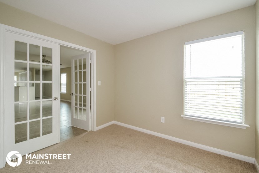 a bedroom with a door to a closet and a window