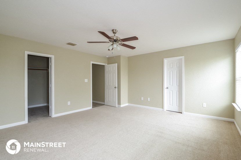 an empty living room with a ceiling fan