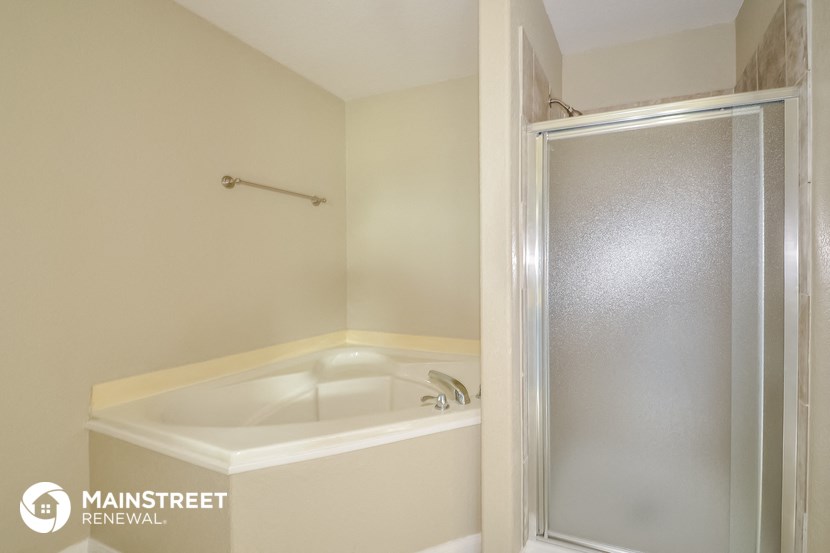 a small bathroom with a shower and a bath tub