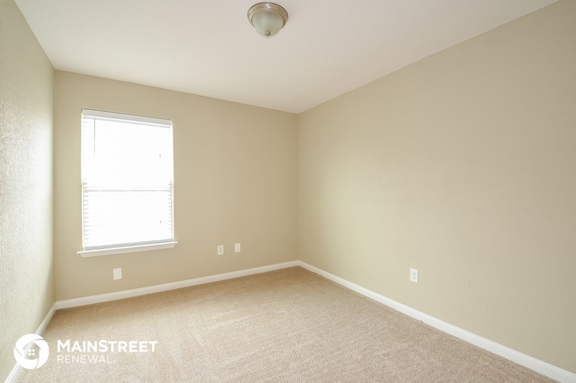 a bedroom with a carpeted floor and a window