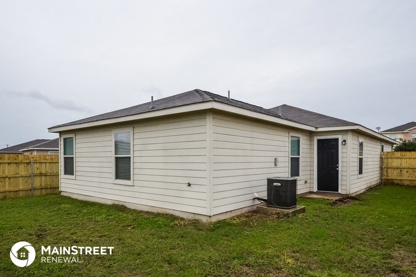 the exterior of a small white house in a backyard