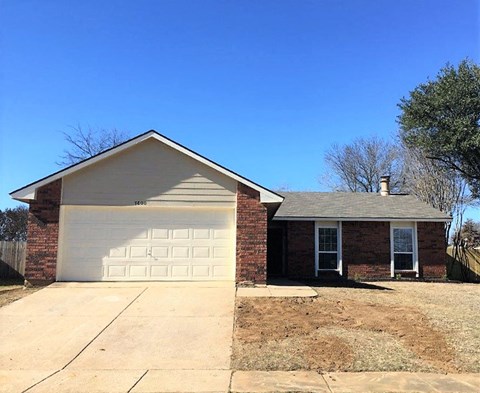 a small brick house with a white garage door