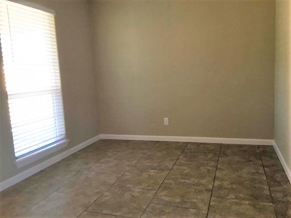 an empty room with tiled floors and a window