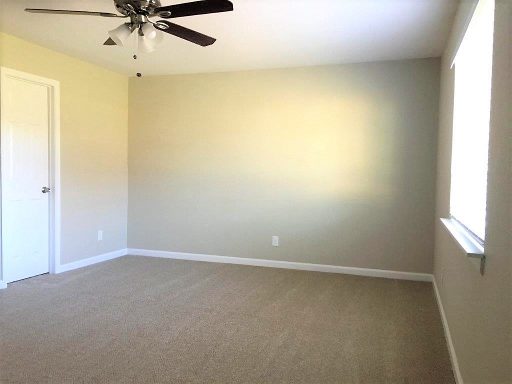 an empty living room with a ceiling fan