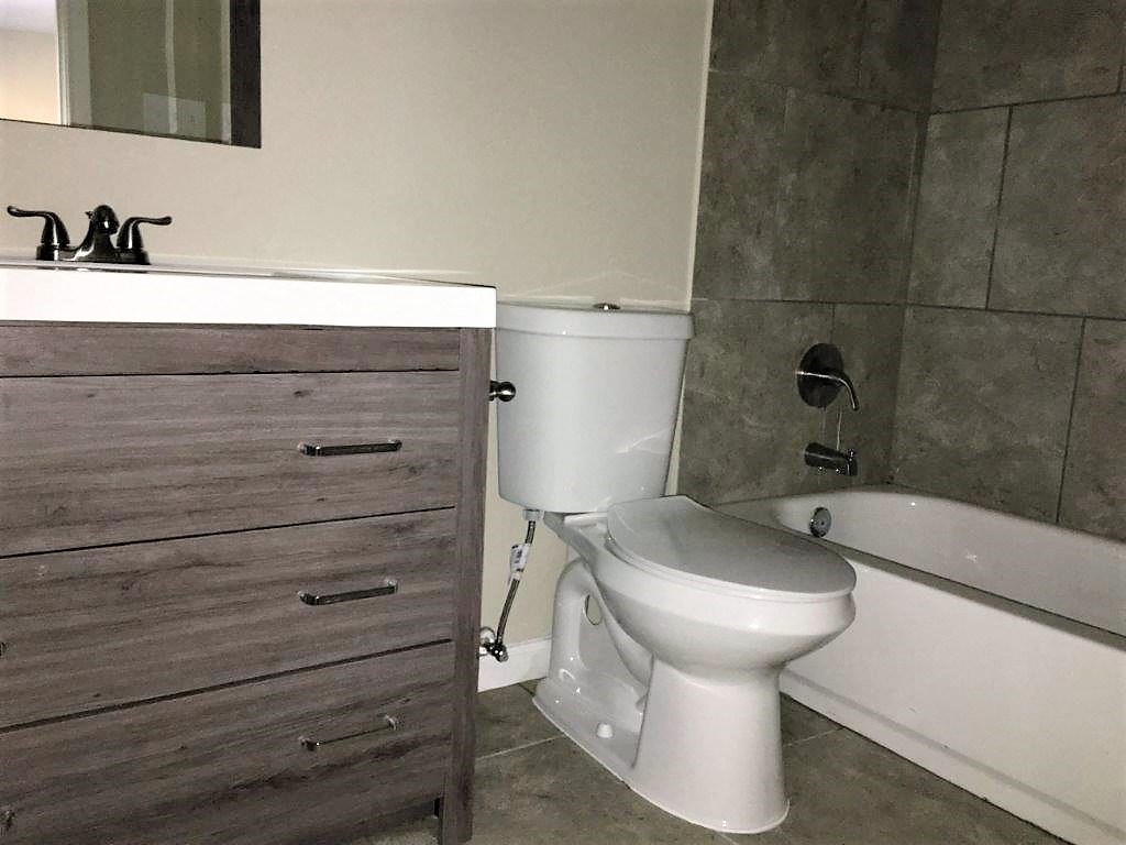 a bathroom with a toilet and a tub and a sink