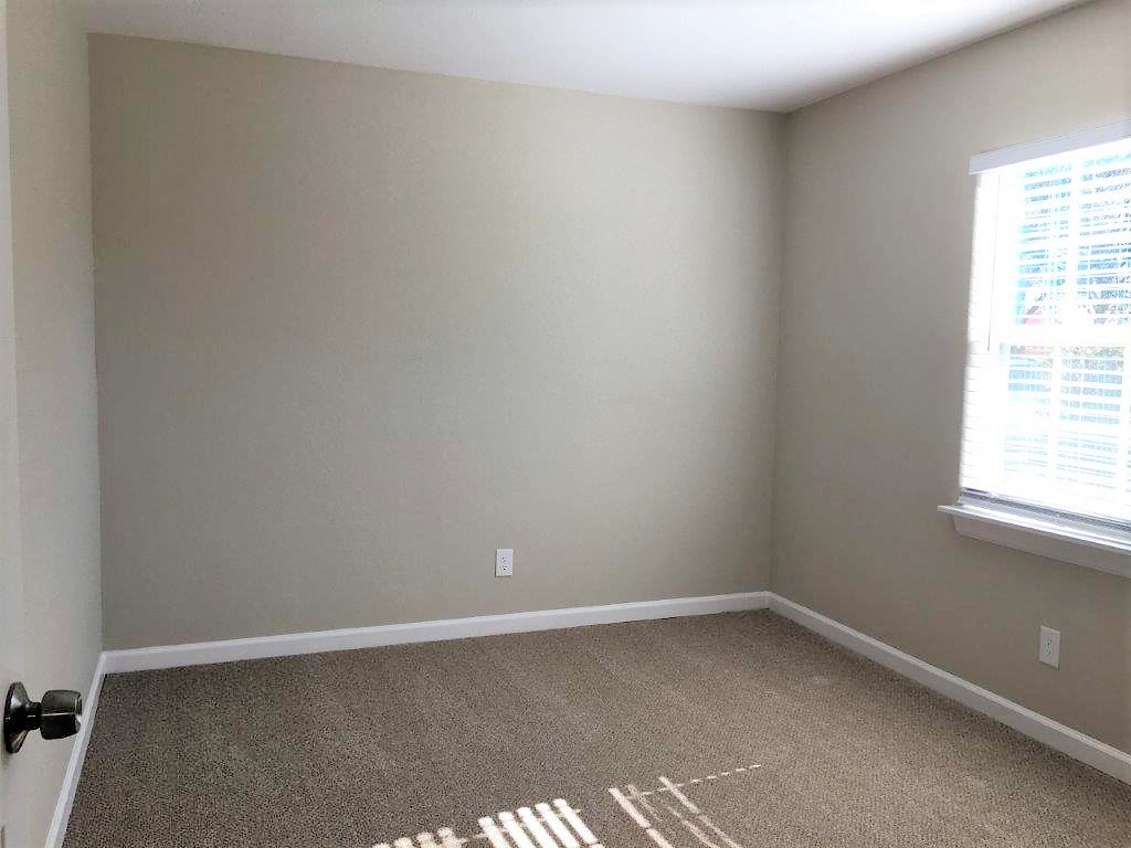 an empty room with a carpet and a window