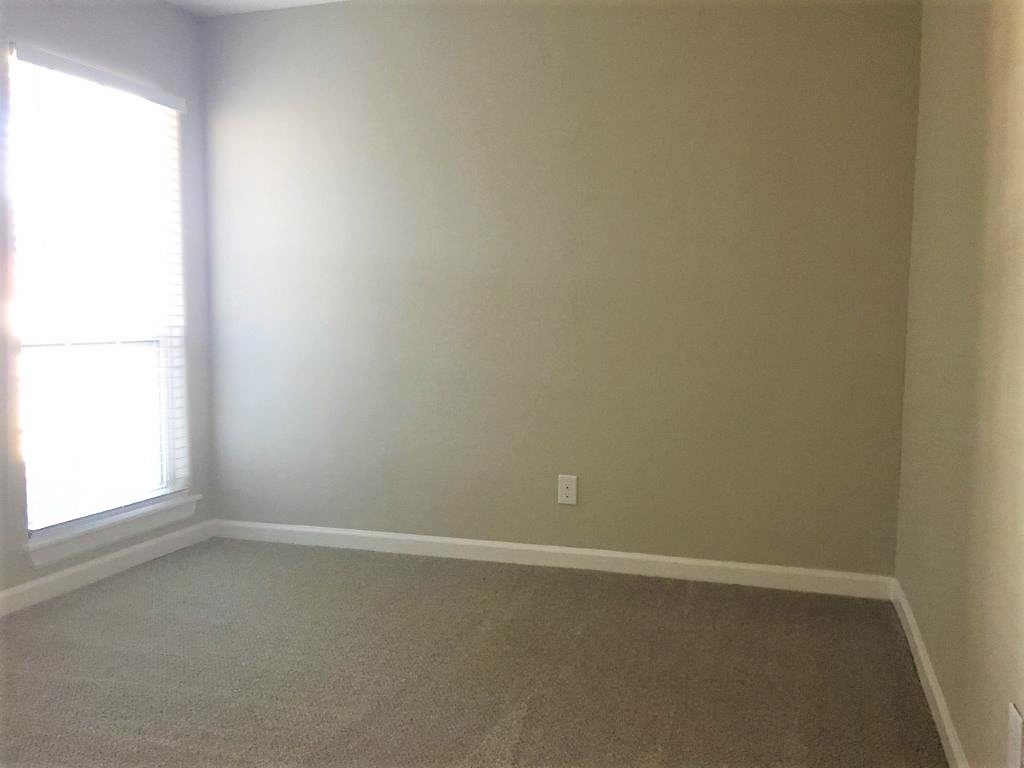 an empty room with white walls and a window