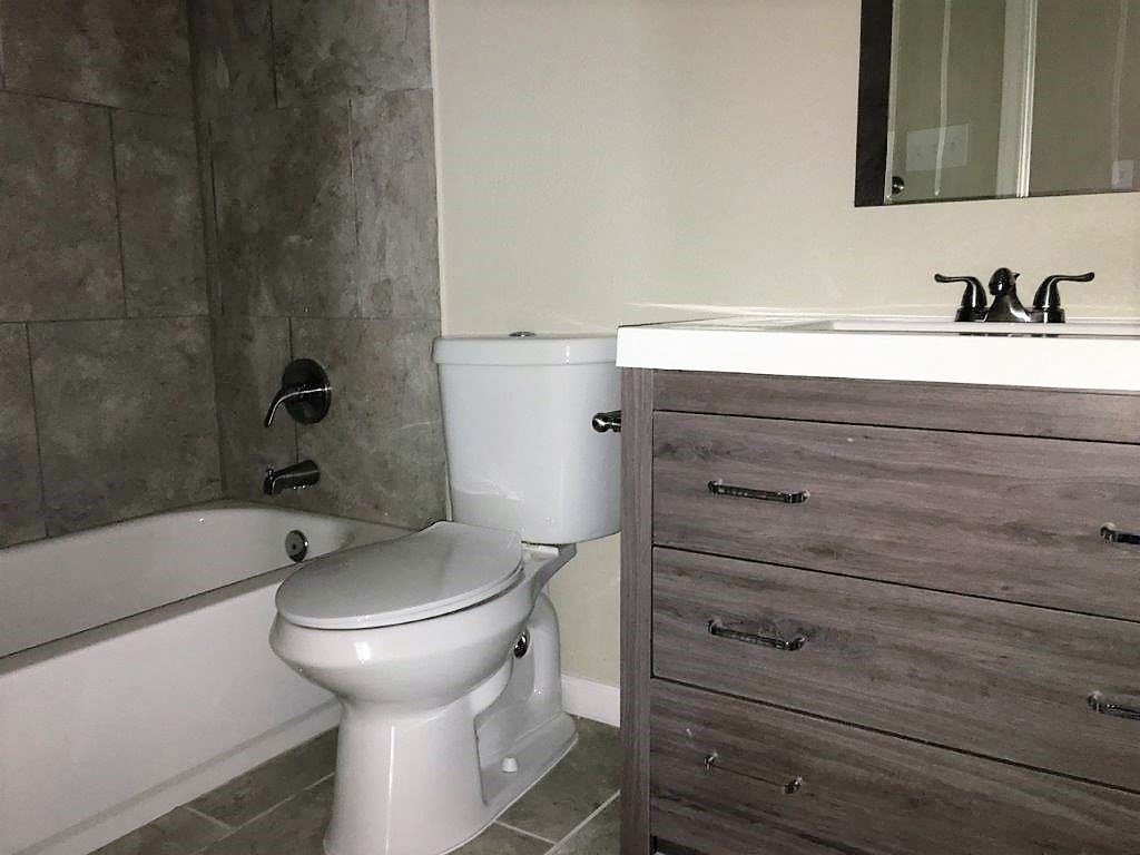 a bathroom with a toilet and a tub and a sink
