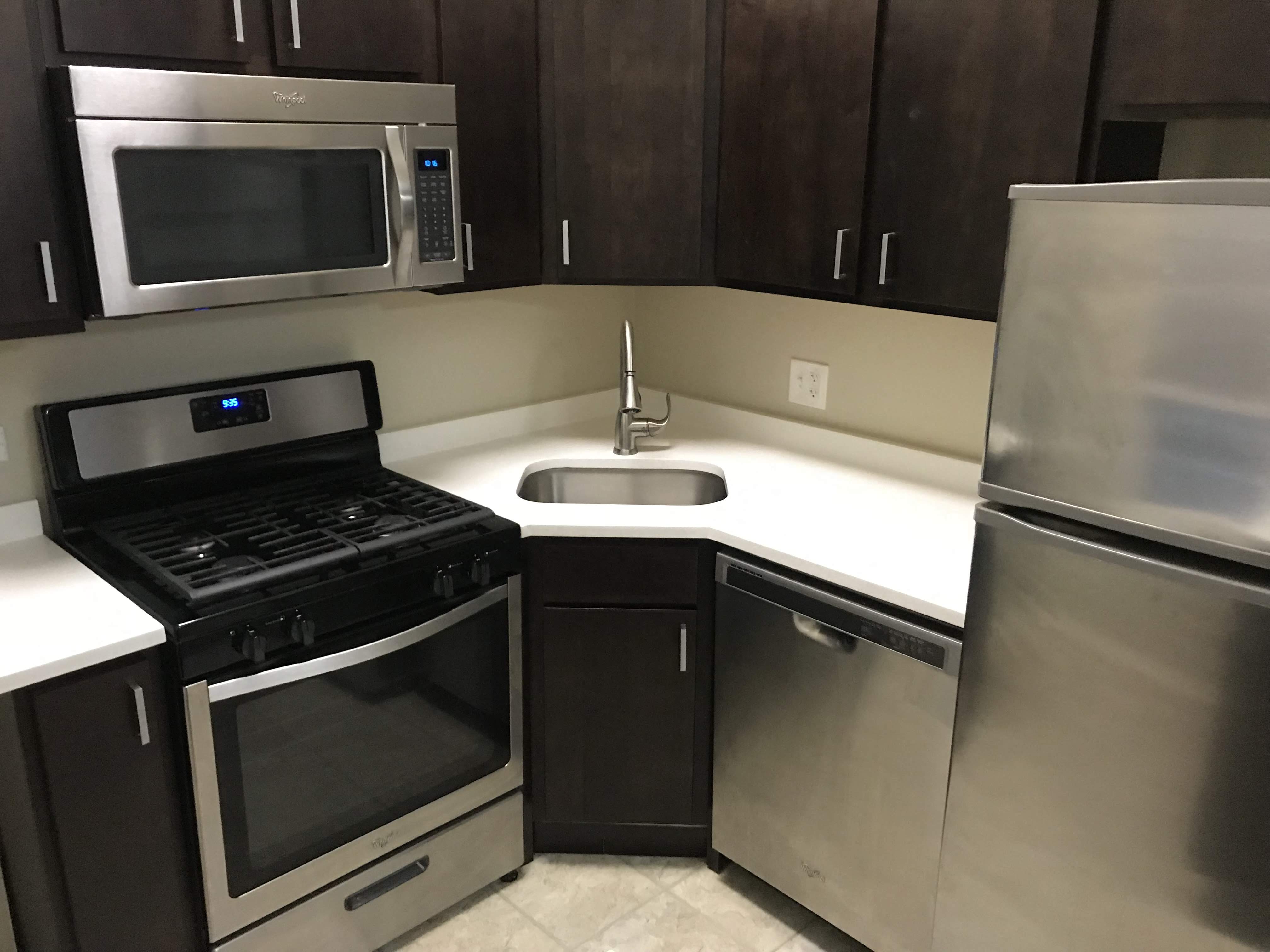 a kitchen with stainless steel appliances and a white counter top