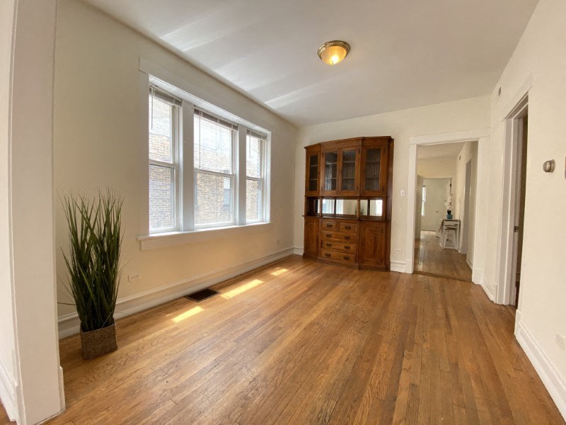 Large windows, built-in wooden cabinetry, and genuine hardwood floors
