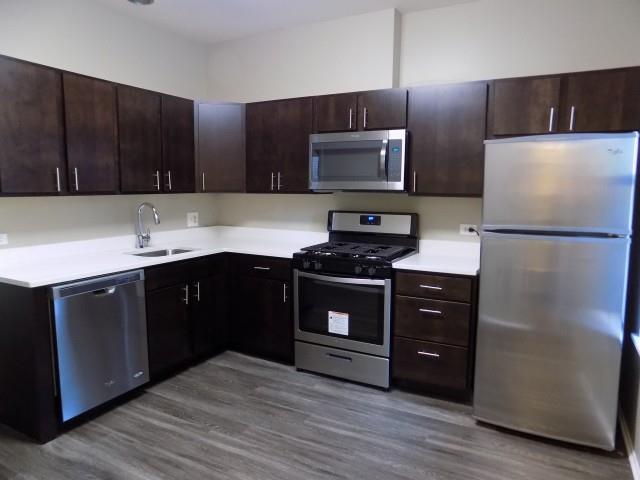 a kitchen with stainless steel appliances and wooden cabinets