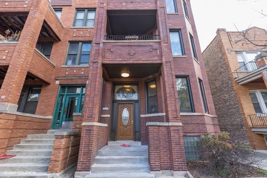 the front of a brick building with stairs and a door