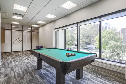 A pool table in a room with a view of the city.