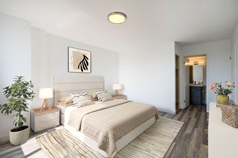 A bedroom with a large bed and a plant on the side table.