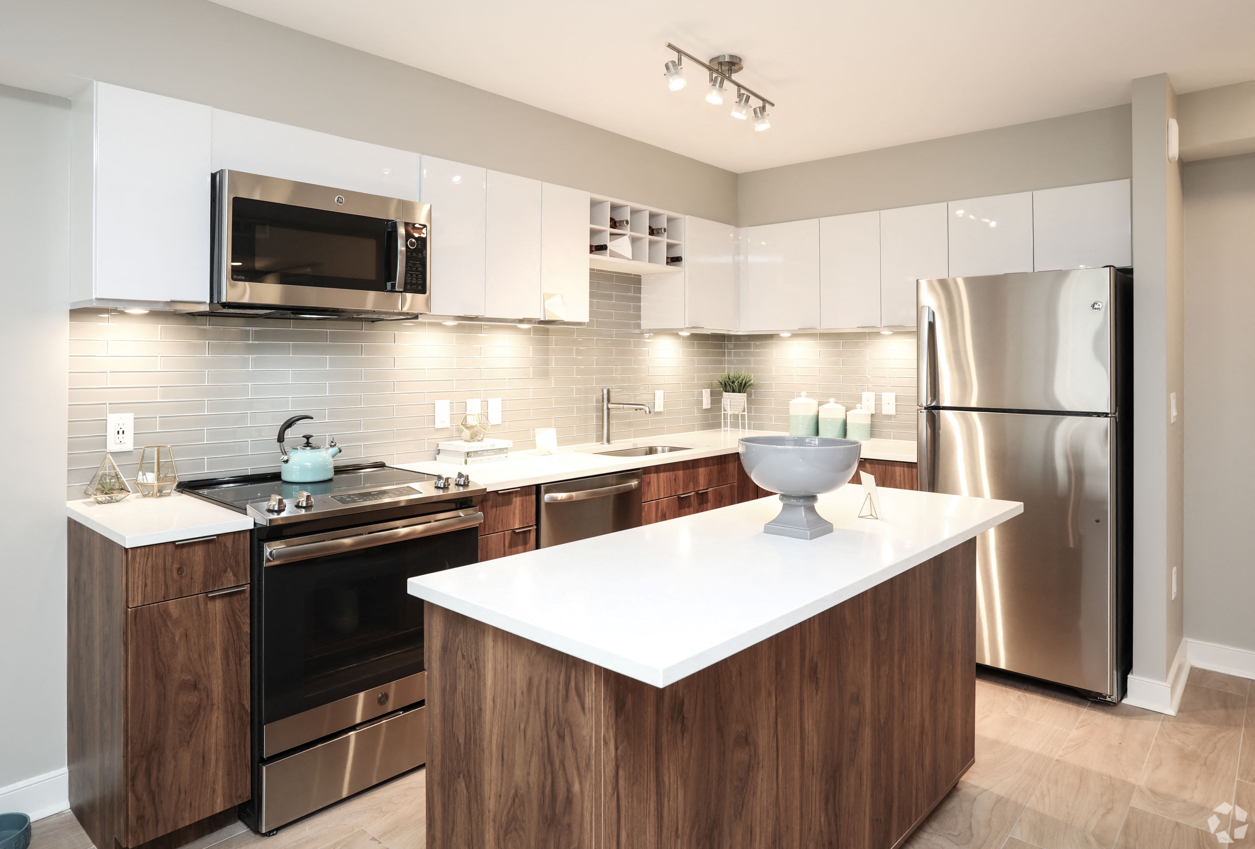 A modern kitchen with a white countertop and wooden cabinets.