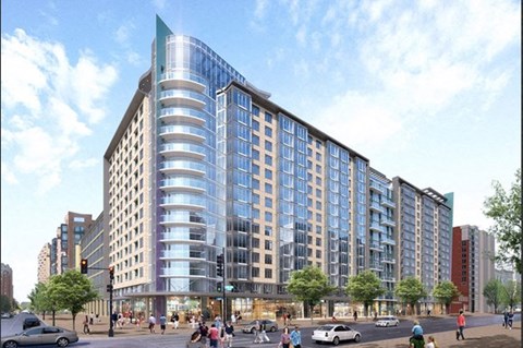 A large, modern building with a curved glass facade is depicted in the image.