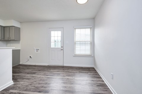 an empty living room with white walls and a white door