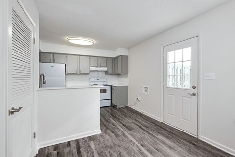 an empty kitchen with a door to the living room