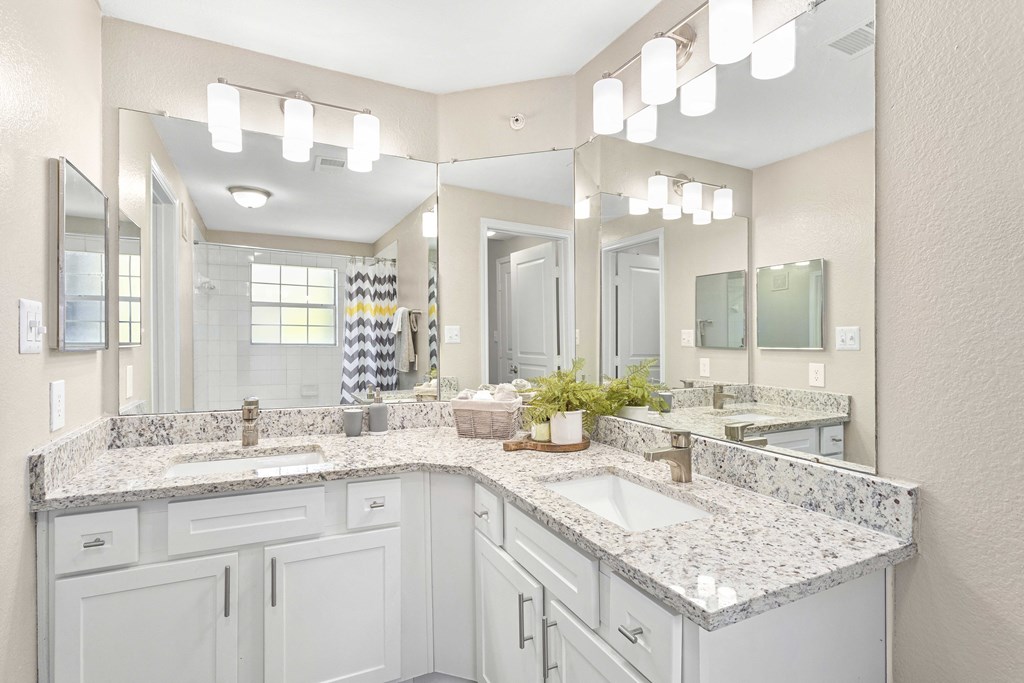 A bathroom with two sinks and a large mirror.