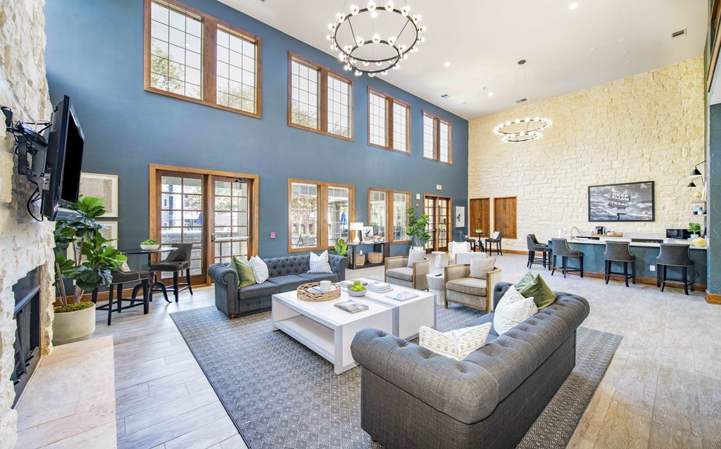 A living room with a grey sofa and a fireplace.