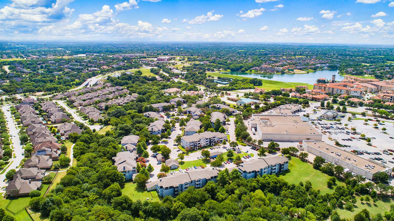 an aerial view of a neighborhood with houses and trees and a lake