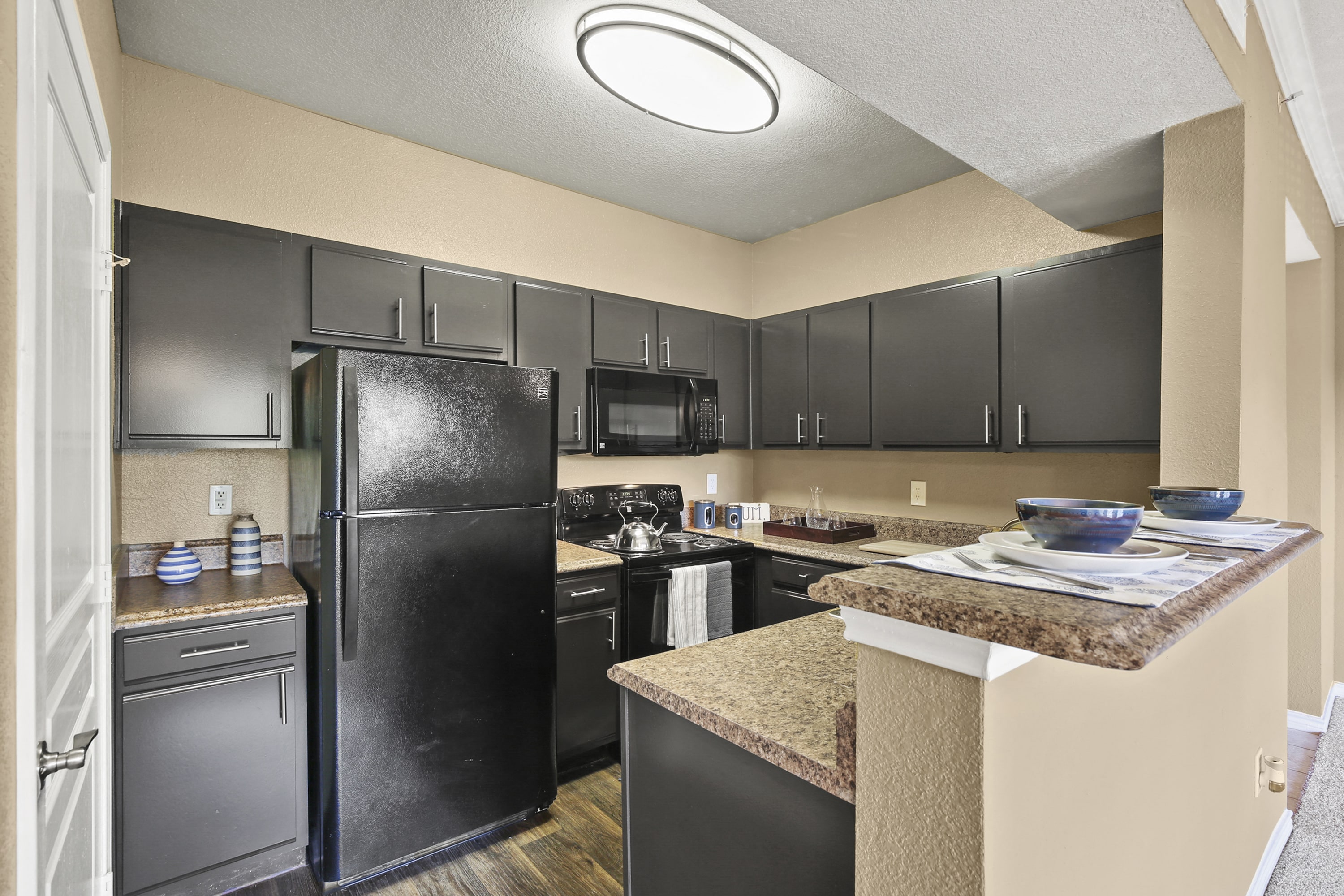 a kitchen with black appliances and granite counter tops