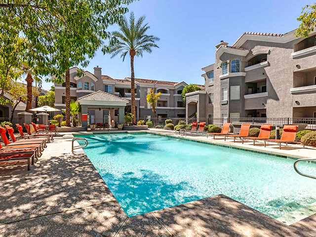 The Highland Apartments Pool during daylight with orange lounge chairs
