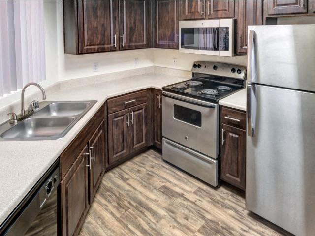 Ingleside Apartments kitchen with dark brown cabinets, white counter tops and stainless steel appliances
