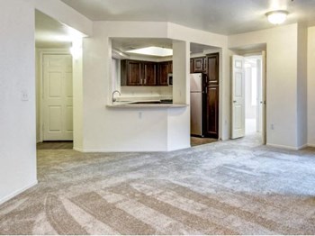 Ingleside Apartments Living Room with wall to wall carpet and kitchen by the front door - Photo Gallery 14